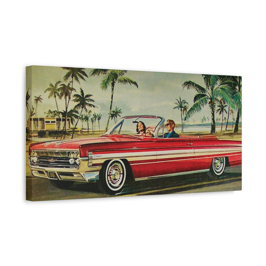  Panoramic view of a red vintage convertible car driving along a coastal road lined with palm trees.