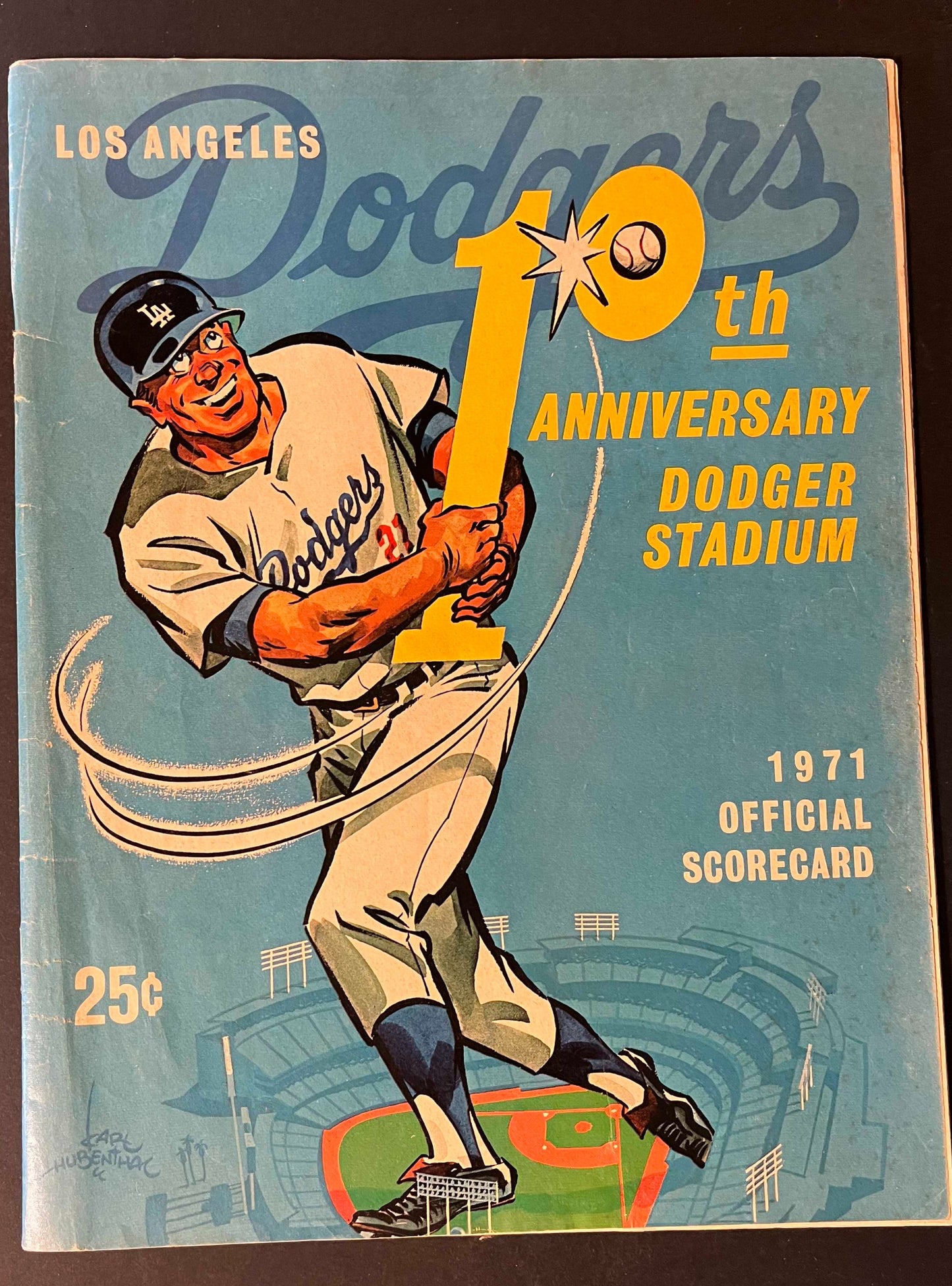 The cover boasts an exuberant illustration of a Dodgers batter in action, encapsulating the excitement of the game against the backdrop of Dodger Stadium and the LA skyline.