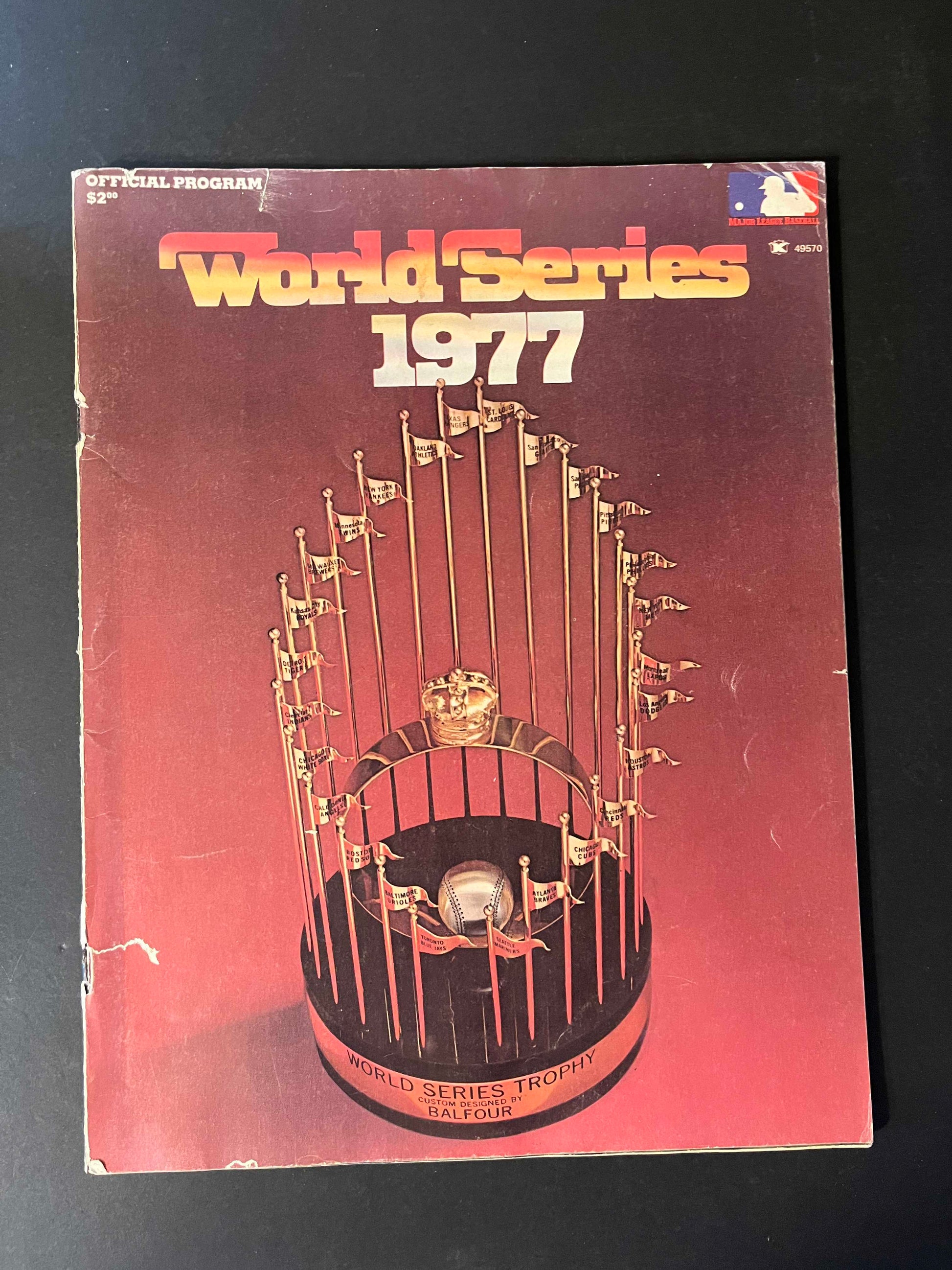 The program cover presents the illustrious World Series Trophy, a beacon of achievement in Major League Baseball, inviting fans to explore the contents that capture a significant moment in sports history.