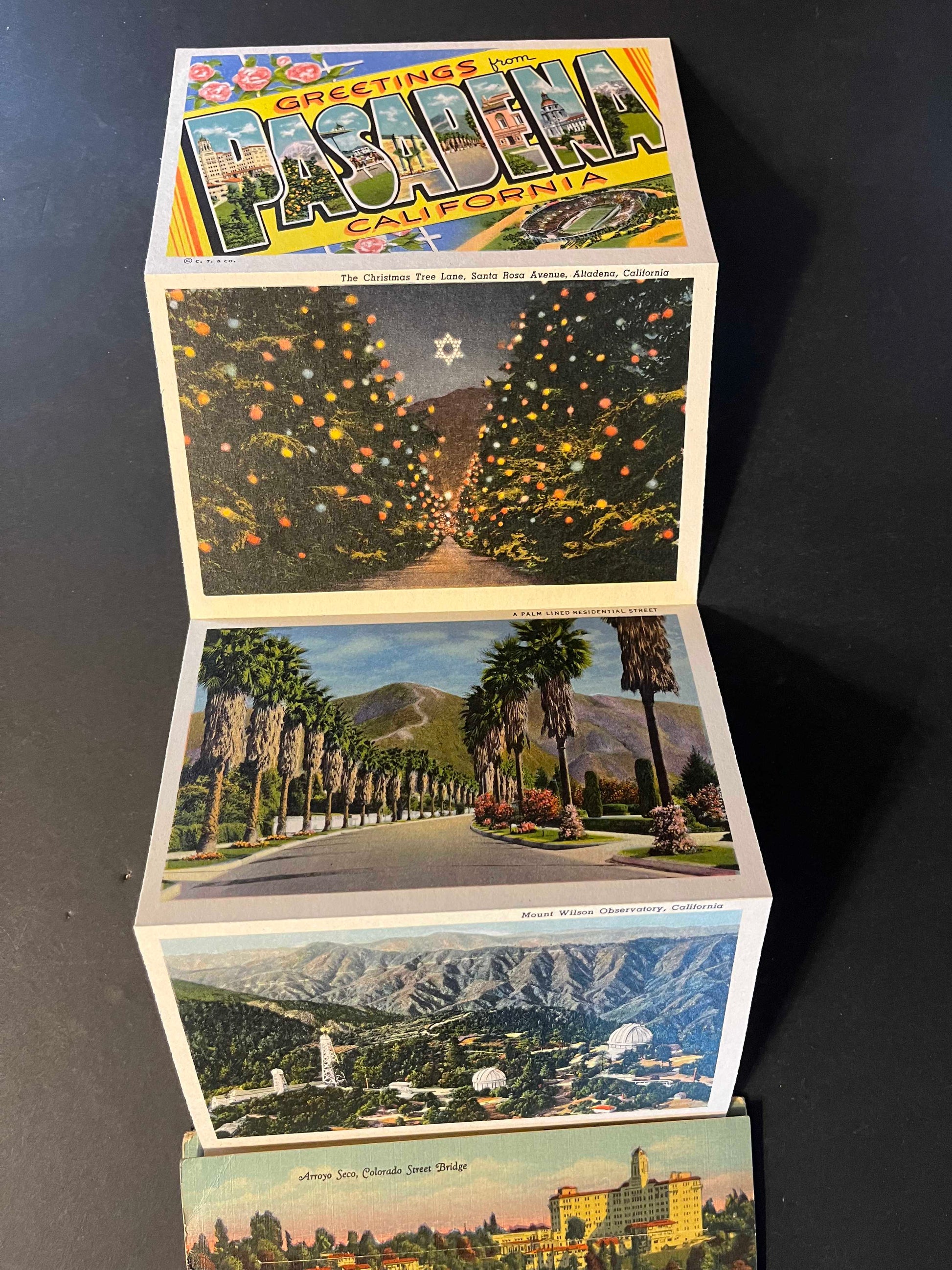 The folder showcases vivid depictions of Pasadena’s attractions, such as the iconic Colorado Street Bridge and the lush grounds of the Los Angeles Turf Club. It unfolds to reveal a treasure trove of hand-picked images that paint a picture of the city's allure in the 1940s.